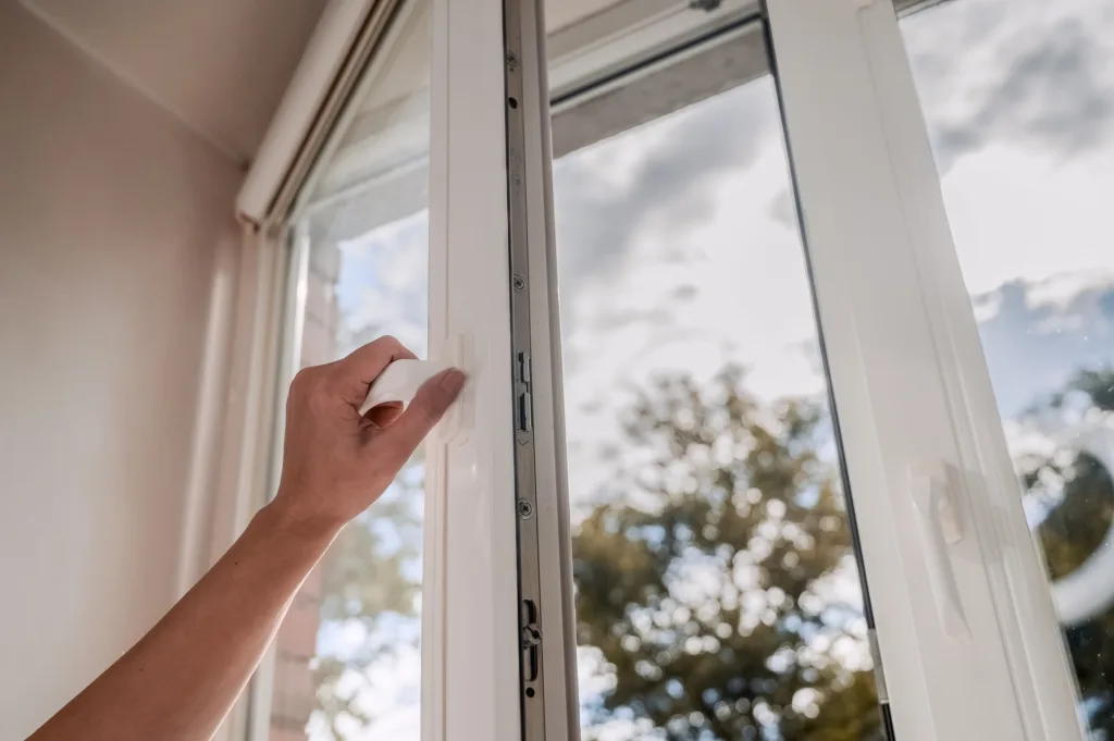 Eine Person öffnet ein Fenster.