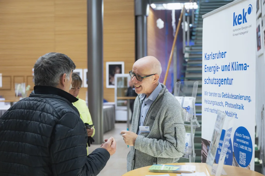 Energieberater berät am KEK Infostand ein Ehepaar. 