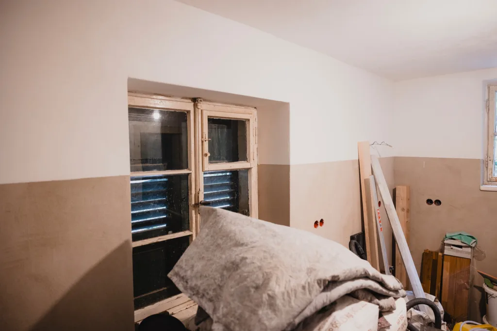 Ein Innenraum des Hauses ist zu sehen, es stehen viele Dinge gestapelt herum. 