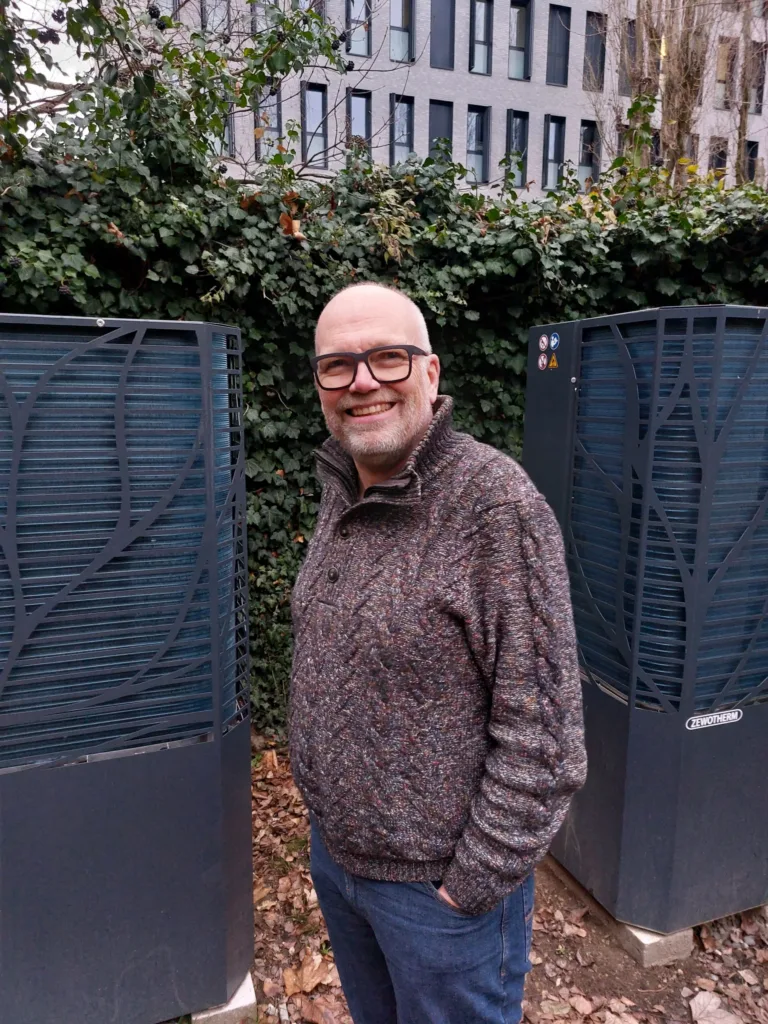 Olaf steht vor den zwei Wärmepumpen im Hinterhof.