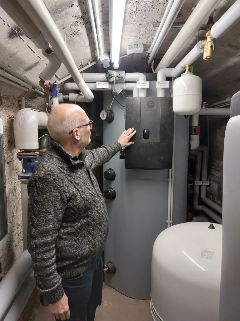 Im Keller zeigt Olaf den Wärmetauscher am Pufferspeicher für die Wärmepumpe.