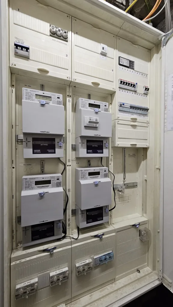 Es ist ein Zählerschrank zu sehen. Es sind Smart Meter installiert.
