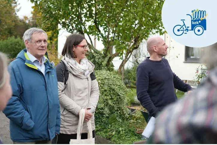 KEK-Energieberater stehen vor einem Haus und hören einem Eigentümer zu, wie er von seiner Sanierung berichtet.
